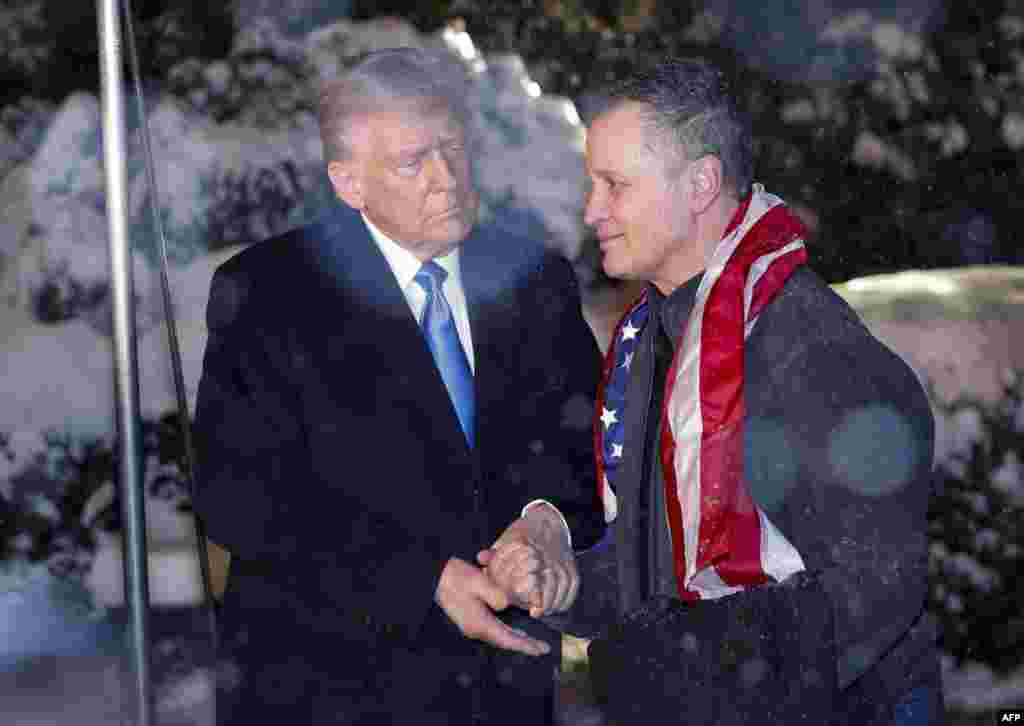 U.S. President Donald Trump greets just-released Marc Fogel, a U.S. teacher detained in Russia since 2021 on drugs charges, as he arrives at the White House under heavy snowfall in Washington on Feb. 11, 2025.