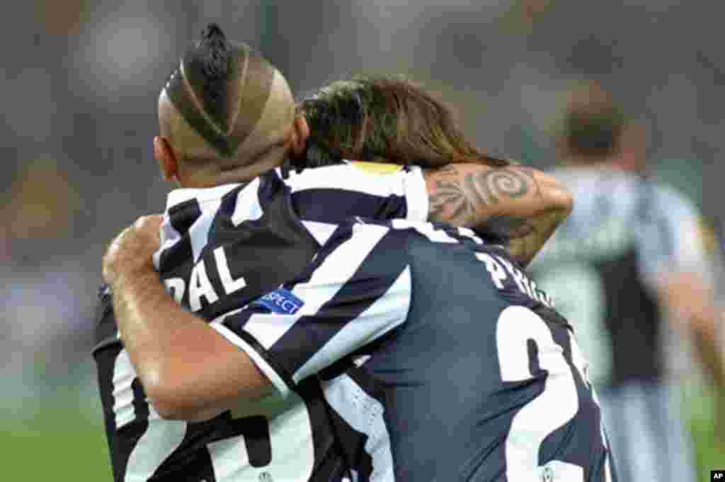 Pemain Chile, Arturo Vidal (kiri) memeluk rekannya dalam sebuah pertandingan antara klub Juventus dan Olympic Lyon di Turin, Italia. 