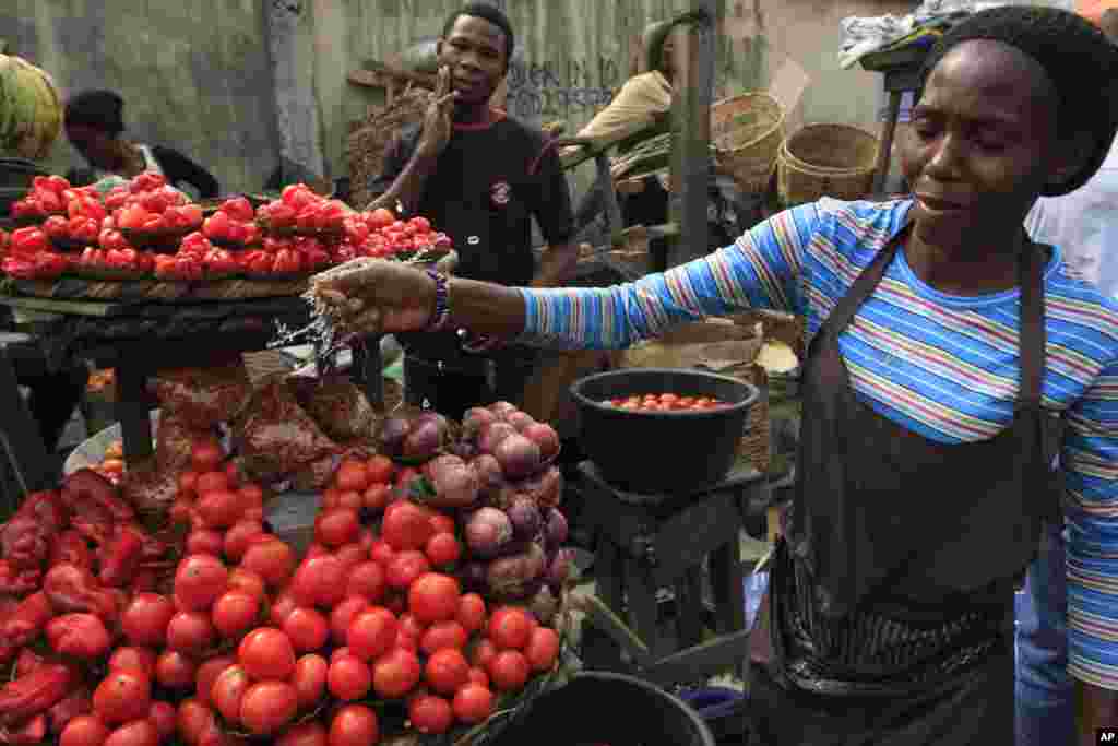 NIGERIA: Strikes by labor unions protesting high gasoline prices caused damage to fresh produce inventories. A woman sells tomatoes at a market in Obalende, Lagos, Nigeria, Saturday, Jan. 14, 2012. 