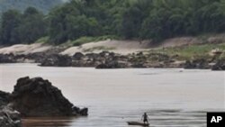 A fisherman works near the site of the proposed Xayaburi Dam in Paksey, northern Laos (File)