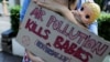 Aktivistkinja za zaštitu životne sredine drži kartonski znak i lutku na protestu u Jakarti u Indoneziji, 16. septembra 2021. (Foto: Reuters/Willy Kurniawan)
