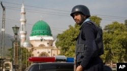 Seorang petugas polisi Pakistan berjaga-jaga di luar kompleks Barri Imam, saat keamanan diperketat di ibukota menyusul serangan bunuh diri di tempat suci sufi di pedalaman Sindh, Islamabad, Pakistan, Jumat, 17 Februari 2017.