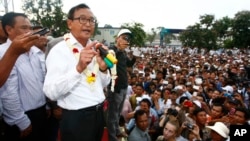 Head of opposition Cambodia National Rescue Party Sam Rainsy, second from left, gives a speech during a rally of their supporters after the July 28 polls, in Phnom Penh, Tuesday, Aug. 6, 2013. 