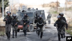 Israeli border police take position during clashes with Palestinian demonstrators as they protest Middle East peace plan announced Tuesday, near the West Bank city of Ramallah, Feb 1, 2020. 