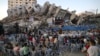 Musisi Palestina tampil di antara reruntuhan Menara Hanadi selama acara yang diselenggarakan oleh Komite Pemuda dan Kebudayaan Palestina di Kota Gaza, Rabu 2 Juni 2021 (Foto: AFP). 