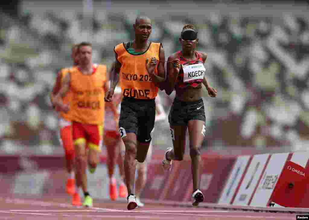 Nancy Chelangat Koech of Kenya and guide Geoffrey Kiplangat Rotich in action REUTERS/Molly Darlington. 