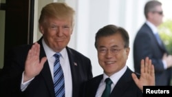 지난 6월 미국 워싱턴 백악관에서 정상회담을 가진 도널드 트럼프 미국 대통령(왼쪽)과 문재인 한국 대통령이 취재진을 향해 손을 흔들고 있다.