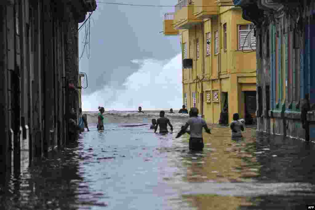 Cubans wade through a flooded street near the Malecon in Havana, Sept. 10, 2017. Deadly Hurricane Irma battered central Cuba, knocking down power lines, uprooting trees and ripping the roofs off homes as it headed towards Florida.
