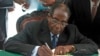 FILE - President Robert Mugabe signs Zimbabwe's new constitution into law in Harare, May 22, 2013.