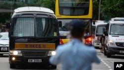Sebuah van penjara, kiri, yang menurut seorang petugas polisi membawa Tong Ying-kit tiba di pengadilan di Hong Kong Rabu, 23 Juni 2021. Tong adalah orang pertama yang diadili berdasarkan Undang-Undang Keamanan Nasional di Hong Kong. (Foto: AP)