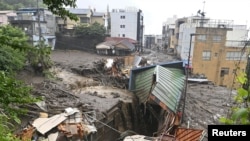 Des maisons endommagées par une coulée de boue à la suite de fortes pluies sont vues dans le district d'Izusan à Atami, au Japon, le 3 juillet 2021. Kyodo/REUTERS.
