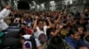 Typhoon survivors who were evacuated from Tacloban city cheer while seated onboard a U.S. military C-17 aircraft after they landed at Manila Airport, Nov. 17, 2013, in Manila, Philippines. 