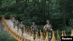 Tentara Pasukan Keamanan Perbatasan India (BSF) berpatroli di atas jembatan dekat Line of Control (LoC), garis gencatan senjata yang memisahkan Kashmir antara India dan Pakistan, di sektor Sabjiyan di distrik Poonch, pada 8 Agustus 2013. (Foto: Reuters)