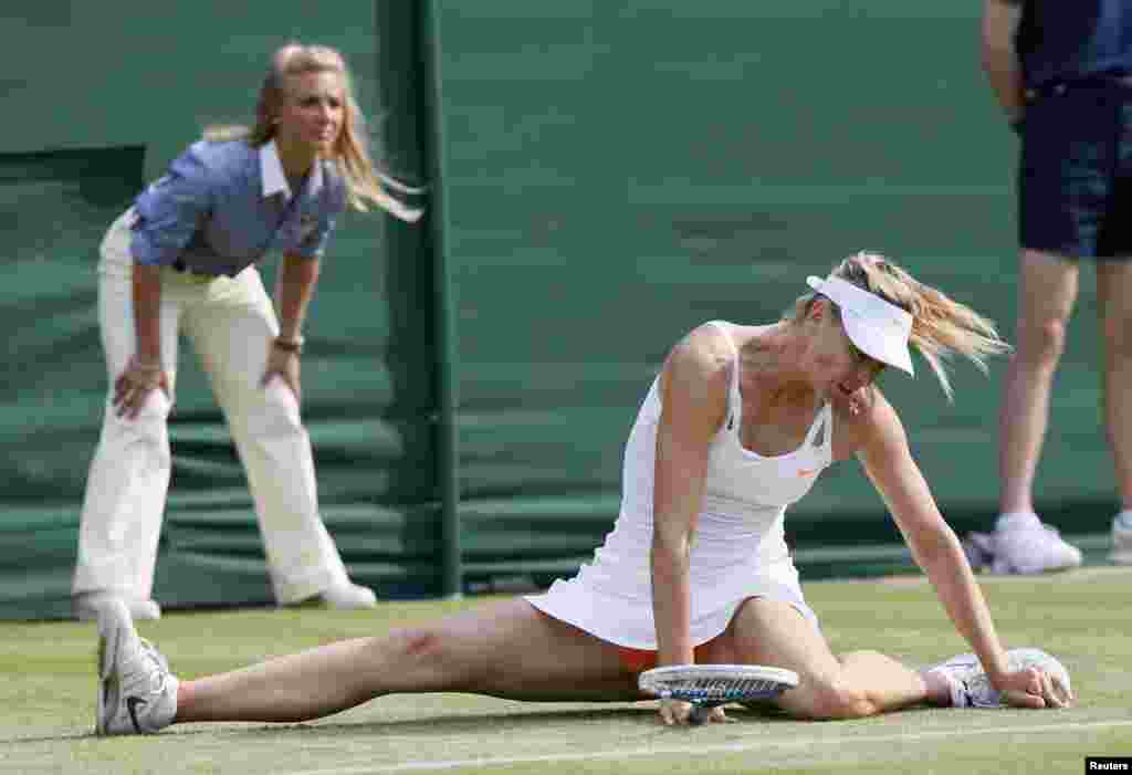 Maria Sharapova of Russia slips during her women's singles tennis match against Michelle Larcher De Brito of Portugal at the Wimbledon Tennis Championships, in London.