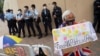 A pro-democracy supporter holds a sign calling for the release of all political prisoners outside Tin Shui Wai police station in Hong Kong, March 22, 2021.