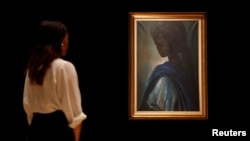 A worker at Bonhams auctioneers poses next to "Tutu," by Nigeria's best-known modern artist Ben Enwonwu, ahead of its sale, in London, Britain February 7, 2018. REUTERS/Peter Nicholls