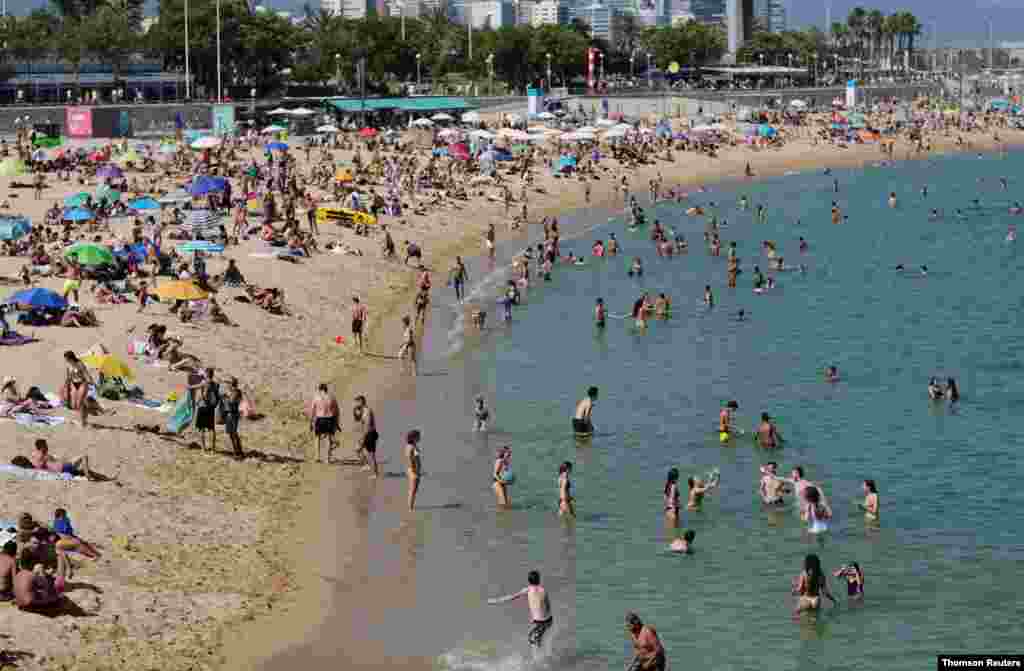 La gente disfruta del clima soleado en una playa de Barcelona, cuando España reabrió oficialmente sus fronteras en medio del brote de la enfermedad del coronavirus (COVID-19).