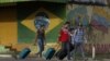 ARCHIVO - En esta fotografía del 9 de marzo de 2018, jóvenes venezolanos sacan su equipaje después de cruzar la frontera hacia Pacaraima, estado de Roraima, Brasil.