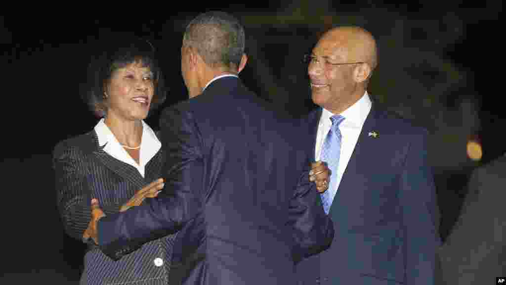 Le président américain Barack Obama, au centre, est accueilli par le Premier ministre Portia Simpson-Miller de la Jamaïque, à gauche, et Patrick Allen, gouverneur général de la Jamaïque, à droite, sur le tarmac après l’arrivée d’Air Force One, le mercredi 8 Avril, 2015 , à l'aéroport international Norman Manley à Palisadoes, Jamaïque