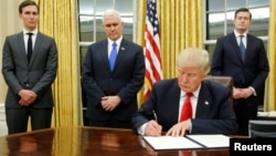 Predsednik Sjedinjenih Država Donald Tramp, uz starijeg savetnika Džerarda Kušnera (levo), potpredsednika Majkla Pensa (sredina) i sekretara osoblja Roba Portera dočekuje novinare u Ovalnom kabinetu i potpisuje svoj prvi izvršni ukaz (REUTERS/Jonathan Ernst)