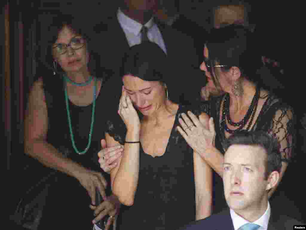Mourners react as they leave the funeral of the Sydney cafe siege victim, cafe manager Tori Johnson, at St. Stephens Uniting Church in Sydney, Australia, Dec. 23, 2014.