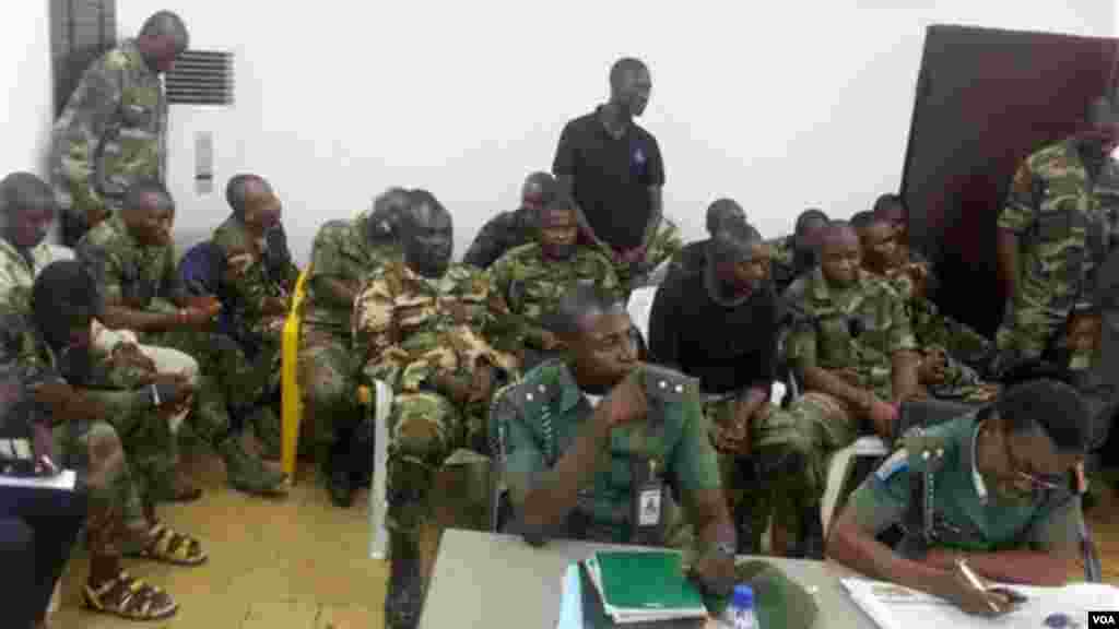 Wasu sojoji masu gabatar da kara ke zaune a layin gaba, yayin da wasau sojojin da ake tuhuma da laifin kai hari kan kwamandansu suka bayyana gaban wata kotun soja a Abuja.