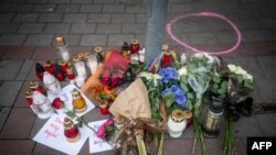 FILE - Candles and flowers have been placed on the pavement outside a gay bar where two men were shot dead the night before, in Bratislava, Slovakia, on Oct. 13, 2022. The attack was linked to the Terrorgram group, an extreme right-wing online network.