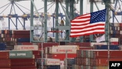 Kontainer-kontainer pengapalan milik China tampak di samping bendera AS saat bongkar muat di Pelabuhan Los Angeles di Long Beach, California, 14 Mei 2019.