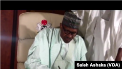 Le président Buhari signe une ordonnance, à Abuja, Nigeria, 21 août 2017.