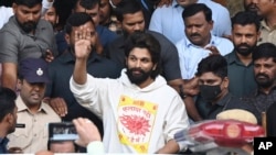 হায়দ্রাবাদে পুলিশ তাঁকে গ্রেপ্তার করার আগে স্বাস্থ্য পরীক্ষার পর হাসপাতাল থেকে বেরোনোর সময়ে ভক্তদের হাত নেড়ে শুভেচ্ছা জানাচ্ছেন ভারতীয় অভিনেতা আল্লু আর্জুন ।১৩ ডিসেম্বর, ২০২৪। 