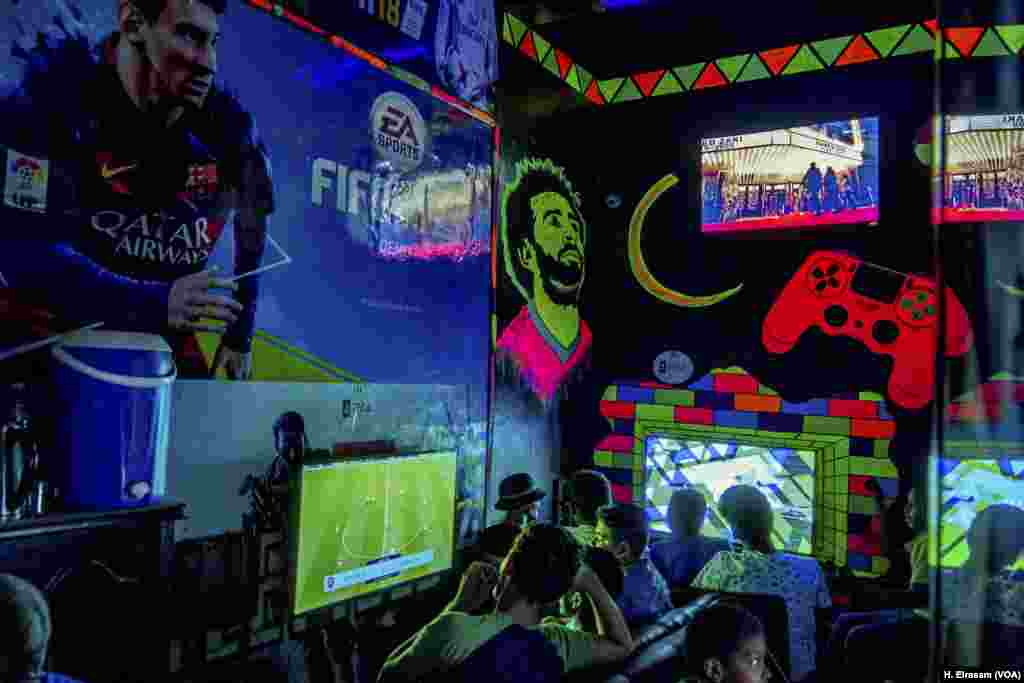 In a video game store, Mohamed Salah’s face shines as young men.