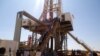 FILE - Engineers and visitors view an exploratory well near Dharoor town, from the port of Bosasso on the Gulf of Aden in Puntland, Somalia, Jan. 17, 2012.