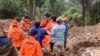 ন্যাশনাল সার্চ অ্যান্ড রেসকিউ এজেন্সি (বিএএসএআরএনএএস) প্রকাশিত এই হ্যান্ডআউট ছবিতে দক্ষিণ সুলাওয়েসির তানা তোরাজায় একটি ভূমিধসের জায়গায় উদ্ধারকারীরা একটি বডি ব্যাগবহন করছেন। ১৪ এপ্রিল, ২০২৪৷