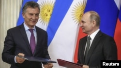 FILE - Russian President Vladimir Putin, right, and his Argentinian counterpart Mauricio Macri attend a signing ceremony following their talks at the Kremlin in Moscow, Russia, Jan. 23, 2018.