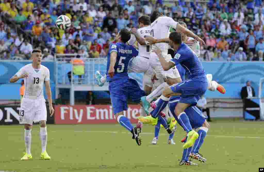 Uruguay's Diego Godin, second right, heads the ball to score his side's first goal during the group D World Cup soccer match between Italy and Uruguay at the Arena das Dunas in Natal, Brazil.