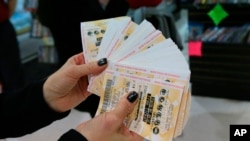 A lottery representative hands out free Powerball tickets at Russ's Market in Lincoln, Neb., as part of a promotion, Wednesday, Feb. 11, 2015.