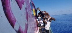 Orang-orang setelah diselamatkan oleh Louise Michel, kapal pencari dan penyelamat migran yang beroperasi di Mediterania dan dibiayai oleh seniman jalanan Inggris Banksy, di laut. (MV Louise Michel via Reuters)