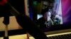 FILE - Tibetan and activist Poet Tsering Woeser appears on computer screen, top, during online video chat with The Associated Press, Beijing, March 1, 2012.