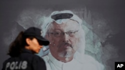 Une policière turque passe devant une photo du journaliste saoudien Jamal Khashoggi à Istanbul, lors du premier anniversaire de son assassinat, le 2 octobre 2019. (Photo: AFP/Lefteris Pitarakis)