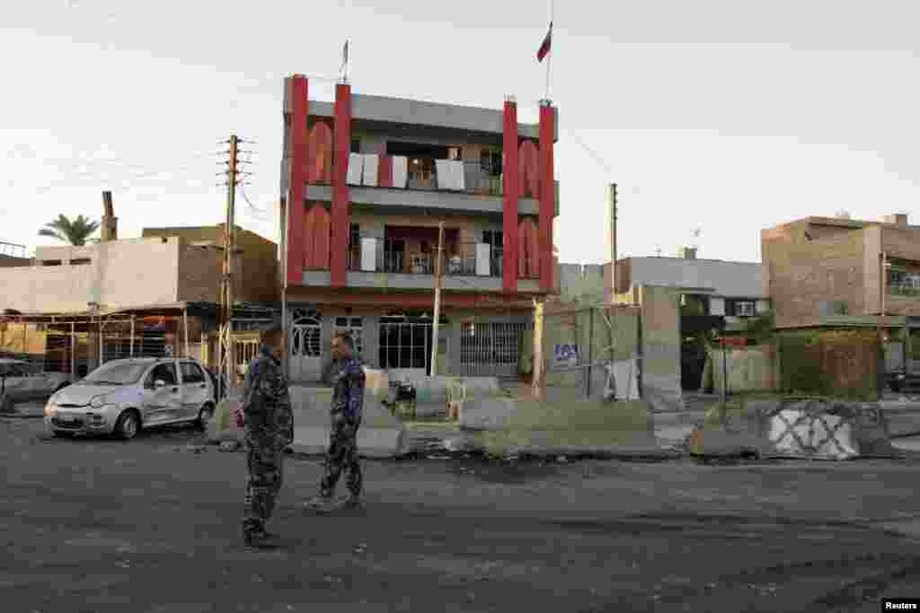 Police inspect the site of an attack that killed at least 18 people and wounded about 50 people when two parked car bombs went off in two mainly Shi'ite districts, in Baghdad's Al-Amil district, Sept. 2, 2014.