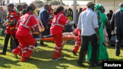 Petugas paramedis merawat orang-orang yang cedera akibat ledakan dalam sebuah pawai umum yang digelar Presiden Emmerson Mnangagwa di Bulawayo, Zimbabwe, 23 Juni 2018.