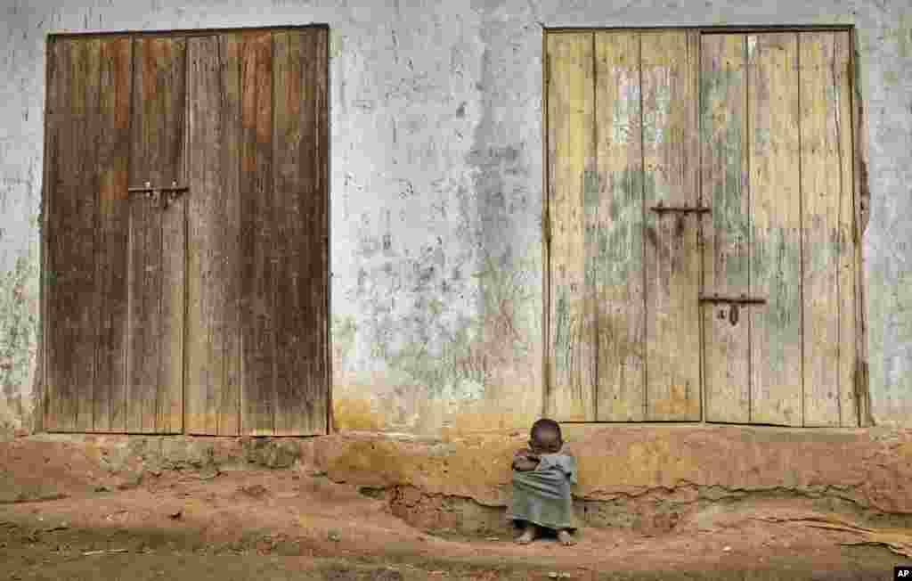Seorang anak laki-laki Uganda duduk di depan rumahnya di desa Kyanukuzi, dekat Masaka, Uganda.