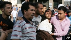 Des manifestants portent un blessé après des affrontements contre la police, à Casablanca, Maroc, 20 février 2011.