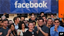 e fondateur et PDG de Facebook Mark Zuckerberg, au centre, sonne la cloche d'ouverture du Nasdaq au siège de Facebook à Menlo Park, Californie, 18 mai 2012.