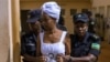 Diane Rwigara escortée par des policiers dans une salle d'audience à Kigali, au Rwanda, le 11 octobre 2017.