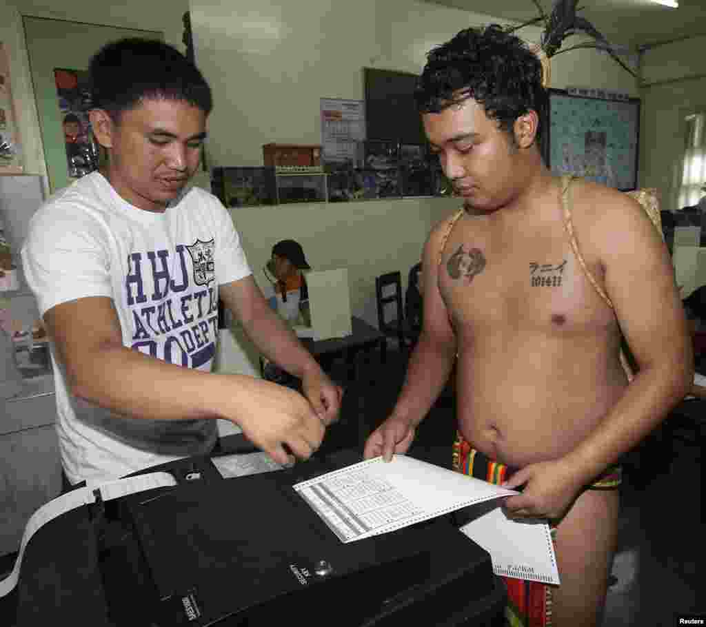A member of a tribal "Igorot" family casts his vote through a voting machine during midterm elections in Baguio city, northern Philippines, May 13, 2013.