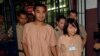 Thai student Patiwat Saraiyaem, 23, left, and activist Porntip Mankong, 26, are escorted by prison security guards after their verdict at the Criminal Court in Bangkok, Feb. 23, 2015. 