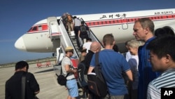 Para penumpang menaiki tangga pesawat Air Koryo yang akan berangkat menuju Beijing, di Bandara Internasional Pyongyang, Korea Utara, 27 Juni 2015. (Foto: dok).