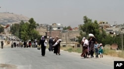 FILE- Syrians carry food as they return to the rebel-held Damascus suburb of Moadamiyeh near Damascus, July 14, 2014.