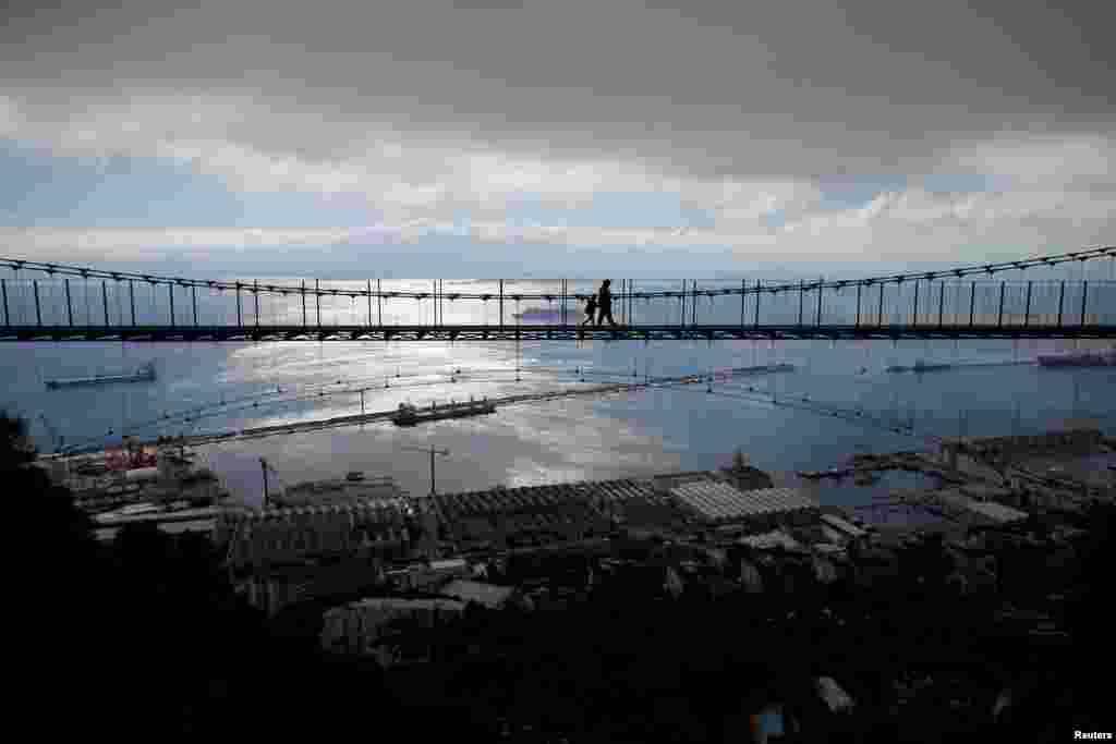 ភ្ញៀវទេសចរដើរកាត់ស្ពាន Windsor Bridge នៅព្រំដែនអង់គ្លេសក្នុងទីក្រុង Gibraltar ដែលទាមទារដោយប្រទេសអេស្ប៉ាញកាលពិថ្ងៃទី១៨ មេសា២០១៨។